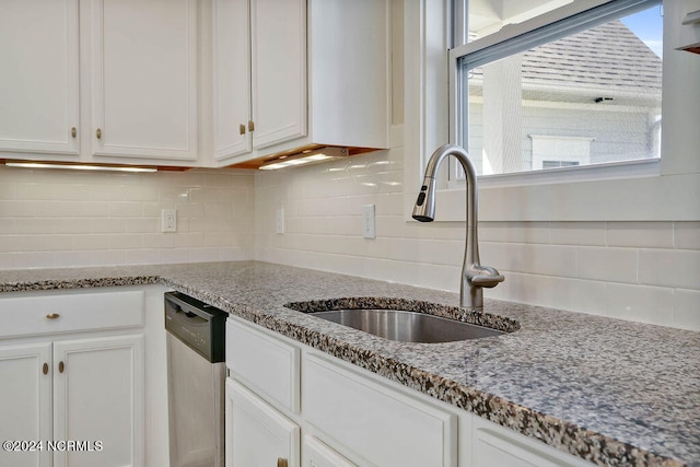 kitchen with dishwasher, a wealth of natural light, light stone countertops, and white cabinets