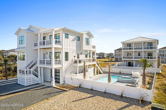 rear view of house featuring a fenced in pool, a patio area, and a balcony