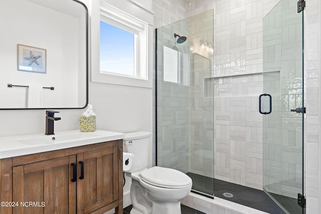 bathroom featuring a stall shower, vanity, and toilet