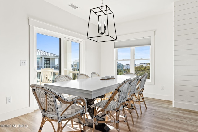 dining area with light wood-type flooring, visible vents, baseboards, and a wealth of natural light