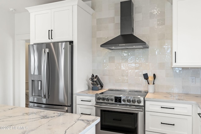 kitchen with white cabinetry, wall chimney exhaust hood, appliances with stainless steel finishes, and tasteful backsplash