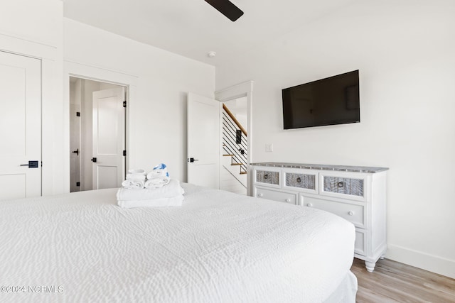 bedroom featuring a ceiling fan, light wood-style flooring, and baseboards