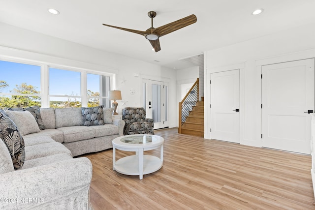 living area with a ceiling fan, recessed lighting, light wood finished floors, and stairs