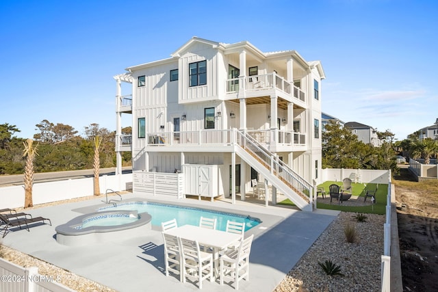 rear view of property with a balcony, a fenced backyard, stairs, a patio area, and board and batten siding