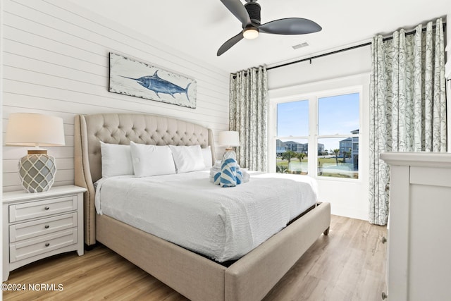 bedroom with light wood-style flooring, visible vents, and a ceiling fan