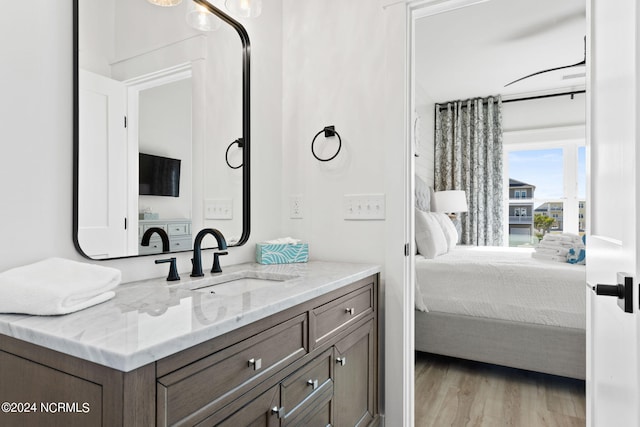 bathroom featuring vanity, connected bathroom, and wood finished floors