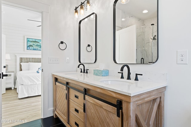 full bathroom featuring ensuite bathroom, double vanity, a sink, and a marble finish shower