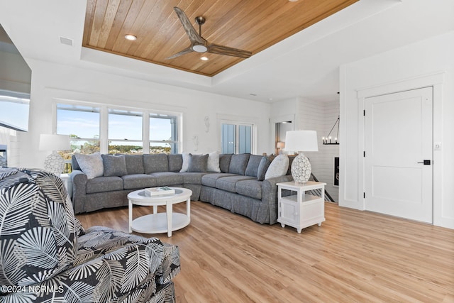 living room featuring recessed lighting, ceiling fan with notable chandelier, wood ceiling, light wood-type flooring, and a tray ceiling