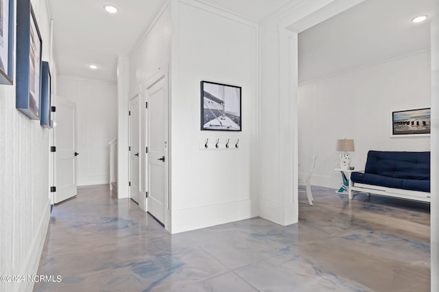 hall featuring finished concrete floors, recessed lighting, and crown molding