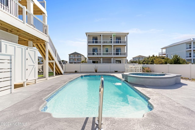 view of pool featuring a pool with connected hot tub, a fenced backyard, stairway, and a patio