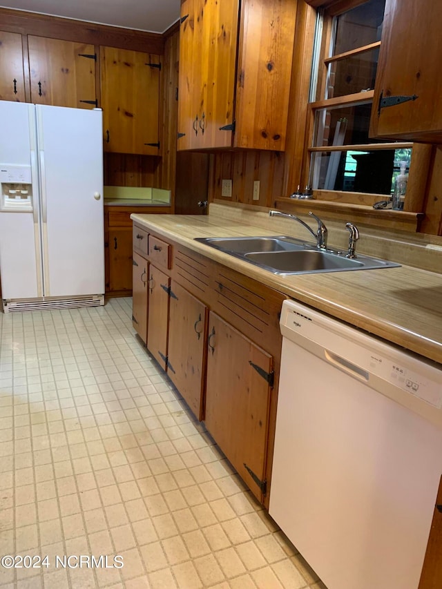 kitchen with wood walls, sink, and white appliances