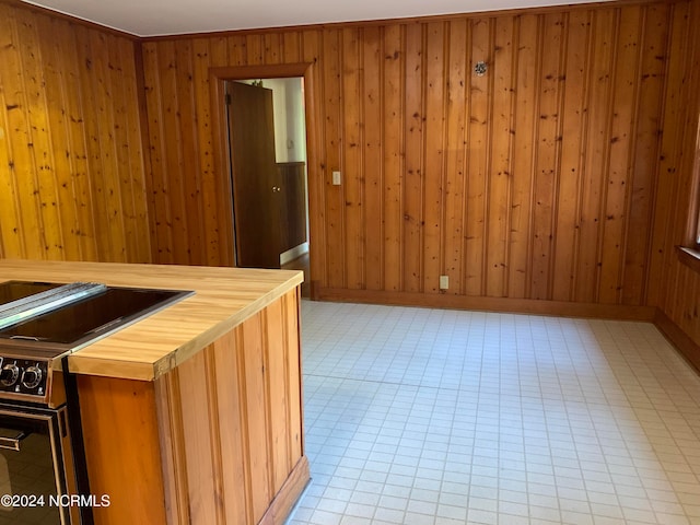 interior space featuring crown molding and wooden walls