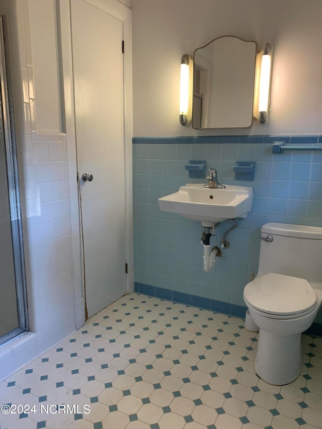 bathroom with tile walls, toilet, sink, and backsplash