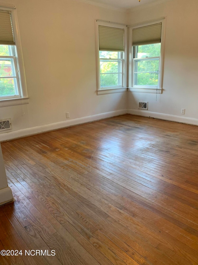 empty room with hardwood / wood-style flooring and a wealth of natural light