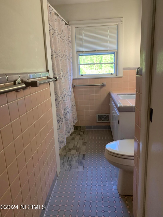 bathroom featuring tile patterned flooring, toilet, tile walls, a shower with curtain, and vanity