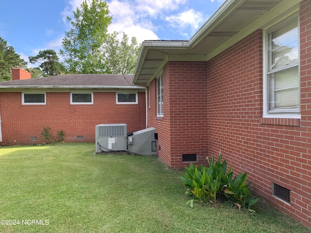 view of home's exterior featuring central air condition unit and a lawn