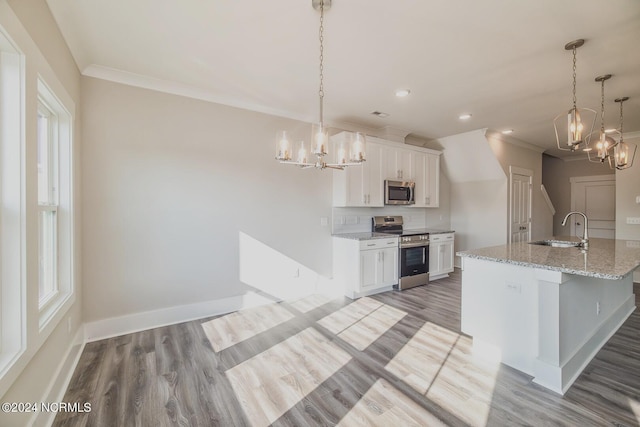 kitchen featuring sink, white cabinetry, hanging light fixtures, and appliances with stainless steel finishes