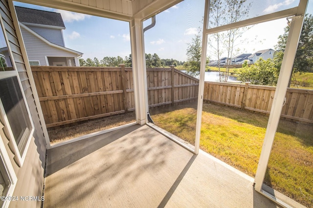 sunroom featuring a water view