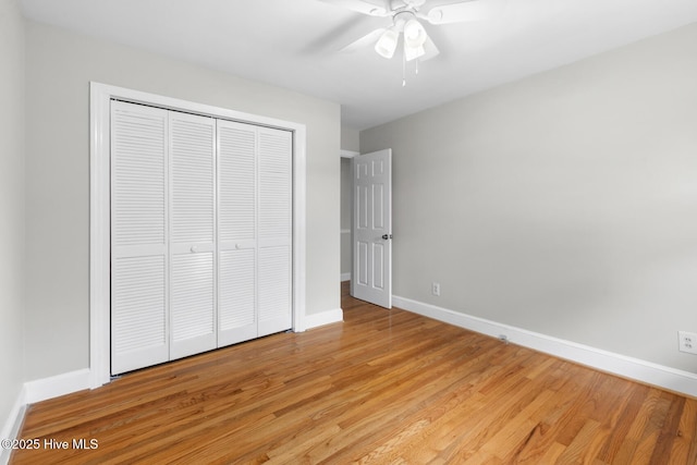 unfurnished bedroom with a closet, light wood-style floors, baseboards, and ceiling fan