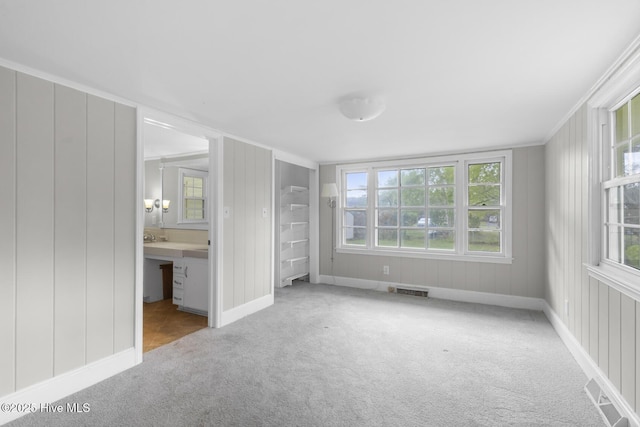 unfurnished bedroom with carpet floors, baseboards, ensuite bathroom, and visible vents