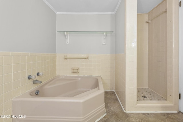 bathroom featuring a shower stall, crown molding, and a garden tub