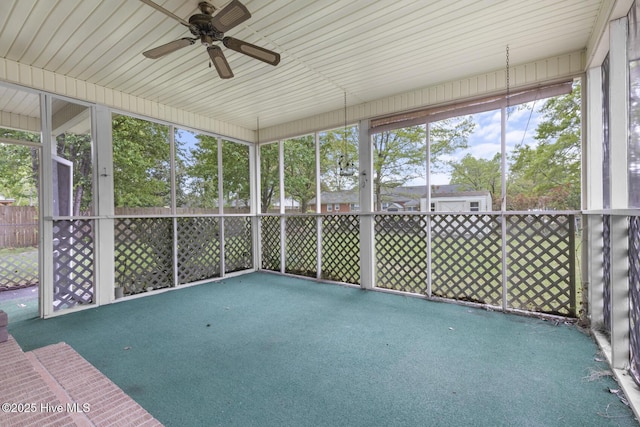 unfurnished sunroom featuring ceiling fan and plenty of natural light