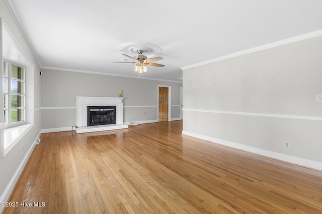 unfurnished living room featuring a fireplace with raised hearth, light wood-style flooring, baseboards, and crown molding