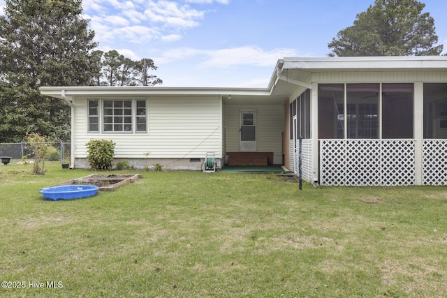 rear view of house featuring a sunroom, crawl space, a lawn, entry steps, and fence