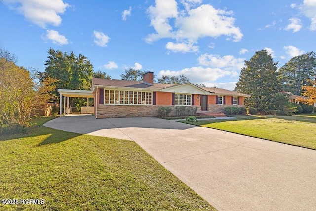 view of front of house with an attached carport, a front yard, driveway, and a chimney