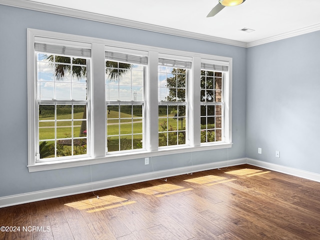 spare room with crown molding, a healthy amount of sunlight, wood-type flooring, and ceiling fan