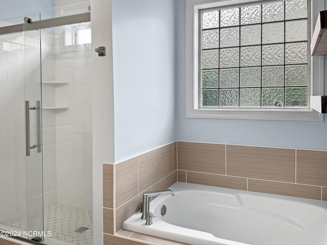 bathroom featuring a wealth of natural light and plus walk in shower