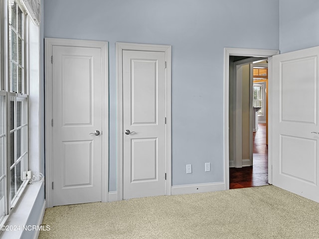 unfurnished bedroom with multiple windows and carpet flooring