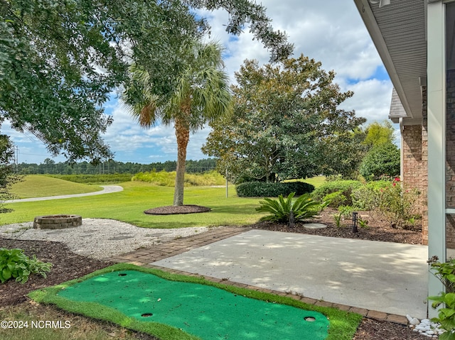 view of property's community featuring a lawn and a patio area