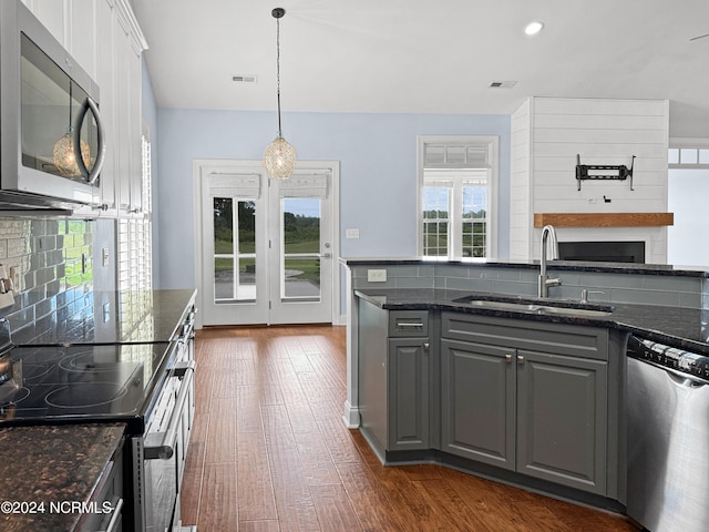 kitchen with dark stone countertops, appliances with stainless steel finishes, and sink