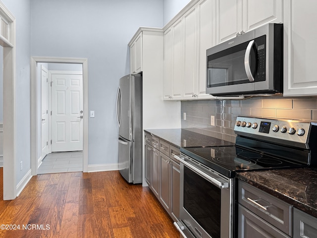 kitchen featuring dark stone countertops, white cabinetry, dark hardwood / wood-style flooring, appliances with stainless steel finishes, and gray cabinetry