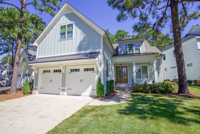 view of front of home featuring covered porch, a front yard, and a garage