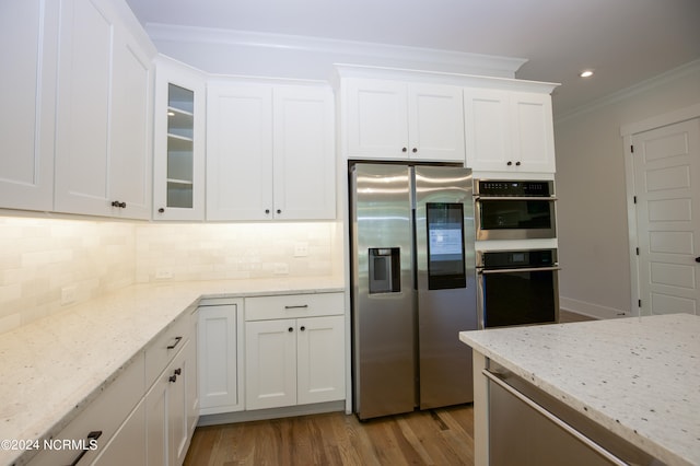 kitchen with appliances with stainless steel finishes, light hardwood / wood-style floors, and white cabinetry