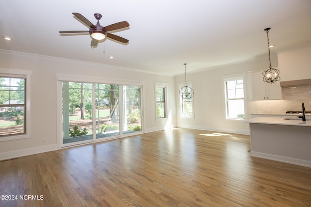 unfurnished living room with light wood-type flooring, ceiling fan, and plenty of natural light