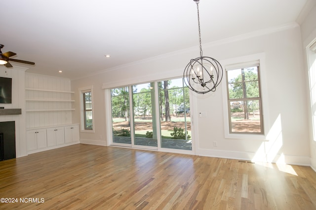 unfurnished living room with ceiling fan with notable chandelier, ornamental molding, and light hardwood / wood-style flooring