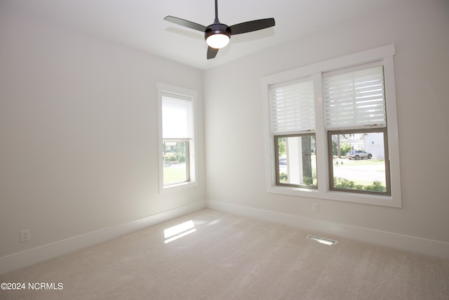 spare room with ceiling fan and light carpet