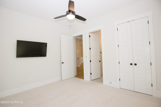 unfurnished bedroom with a closet, ceiling fan, and light colored carpet