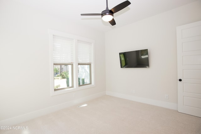 empty room featuring light colored carpet and ceiling fan