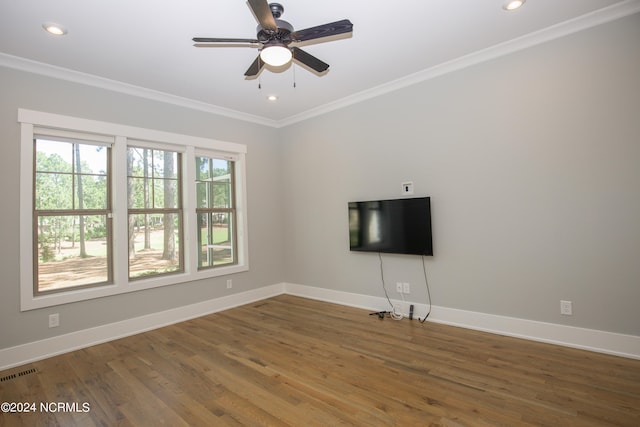 empty room with ceiling fan, ornamental molding, wood-type flooring, and a healthy amount of sunlight