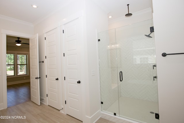 bathroom featuring an enclosed shower, ceiling fan, hardwood / wood-style flooring, and ornamental molding