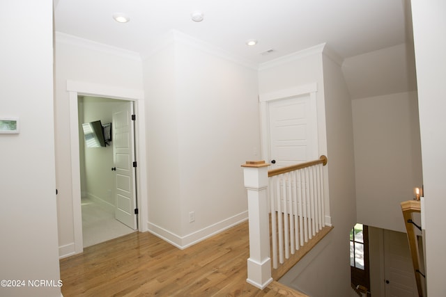 hallway with crown molding and light hardwood / wood-style floors