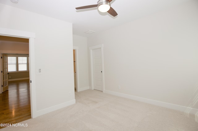 spare room featuring ceiling fan and light colored carpet