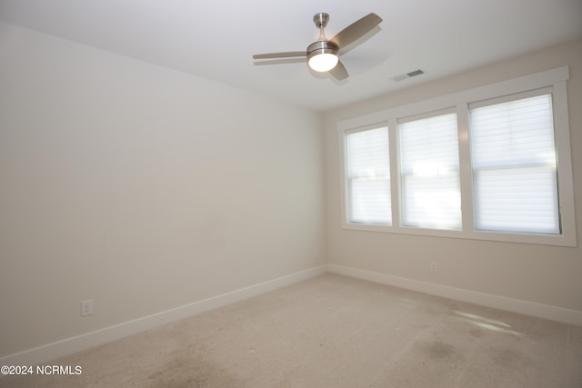 carpeted spare room with ceiling fan