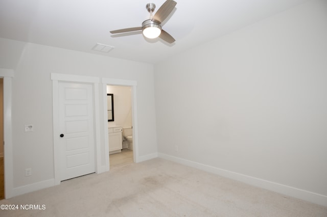 unfurnished bedroom with ceiling fan, light carpet, and ensuite bath