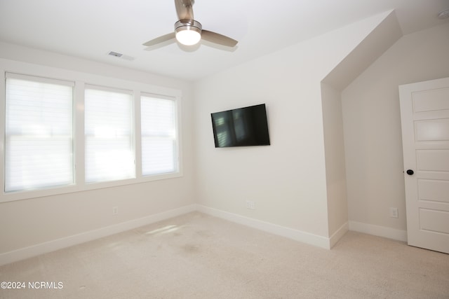 carpeted empty room with ceiling fan and vaulted ceiling