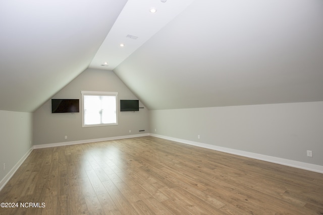 additional living space featuring lofted ceiling and light hardwood / wood-style floors